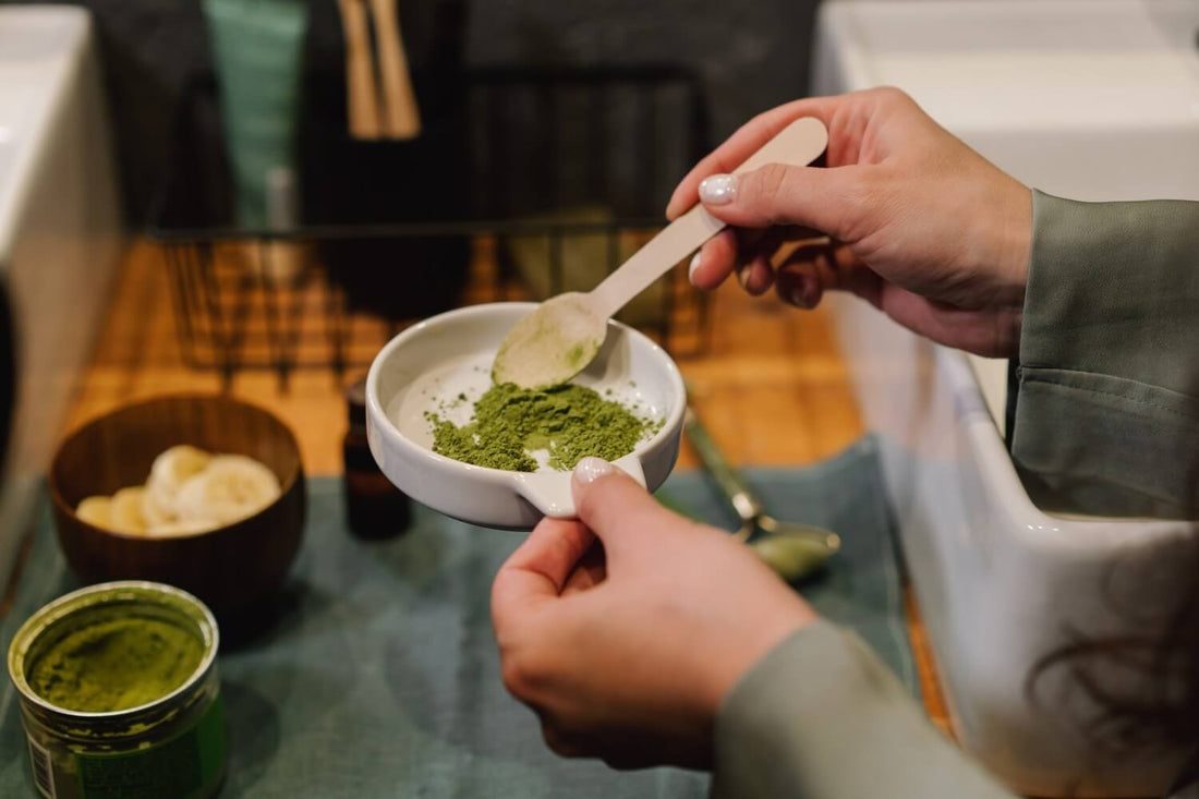 person holding a ceramic bowl with green powder