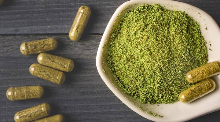 Bowl of kratom powder and capsules